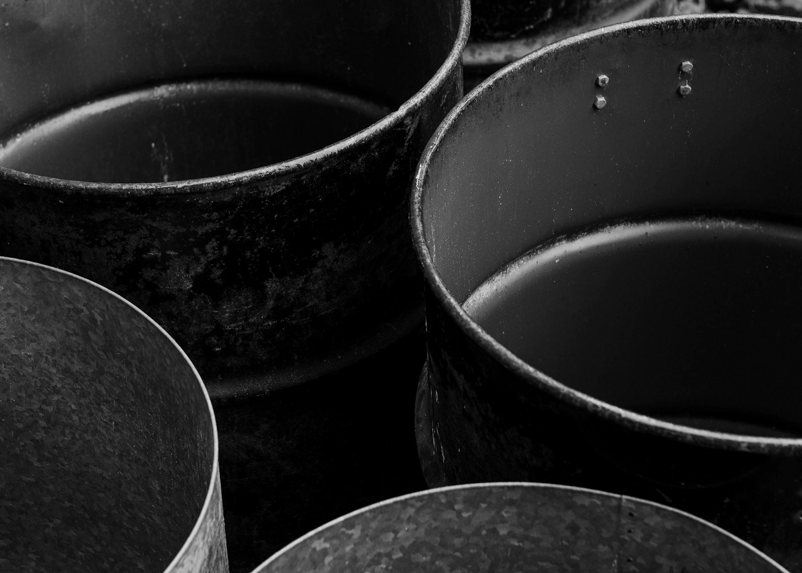Puste metalowe bębny widziane od góry, czarno-białe zbliżenie